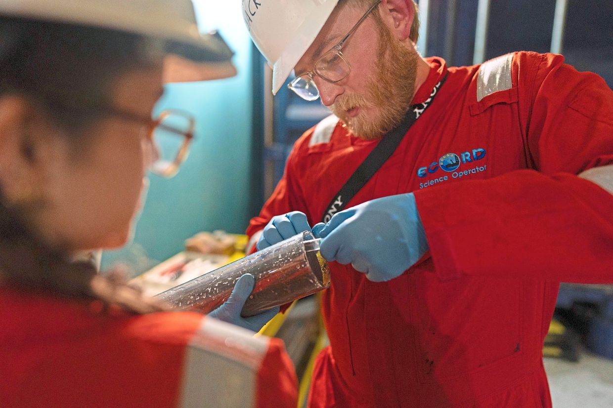 Jack brickell and alize Longeau extracting samples from a corebefore taking it to the curation container aboard the ‘Liftboat robert platform’. — AP