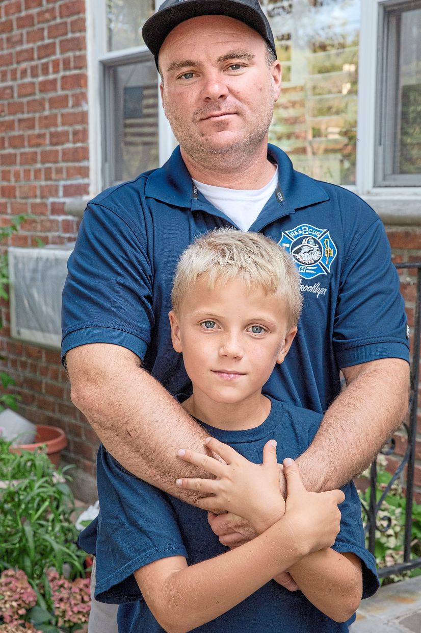 Thomas with his son Tommy, 10, who participated in the recitation of names of victims at the 2025 9/11 memorial service.— Natalie Keyssar/The New York Times