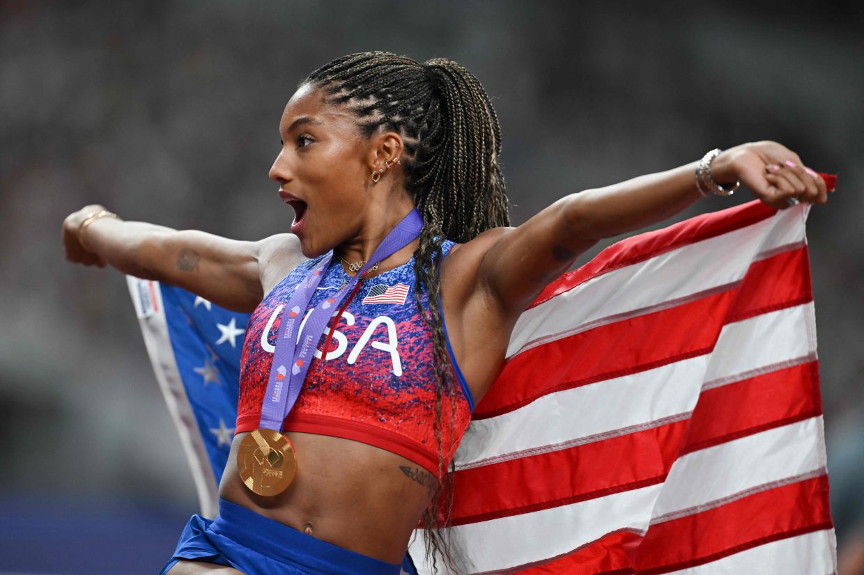 TOPSHOT - US athlete Tara Davis-Woodhall celebrates with her gold medal after winning the women's long jump final during the World Athletics Championships in Tokyo on Sunday, September 14, 2025. -- Photo by Andrej ISAKOVIC / AFP