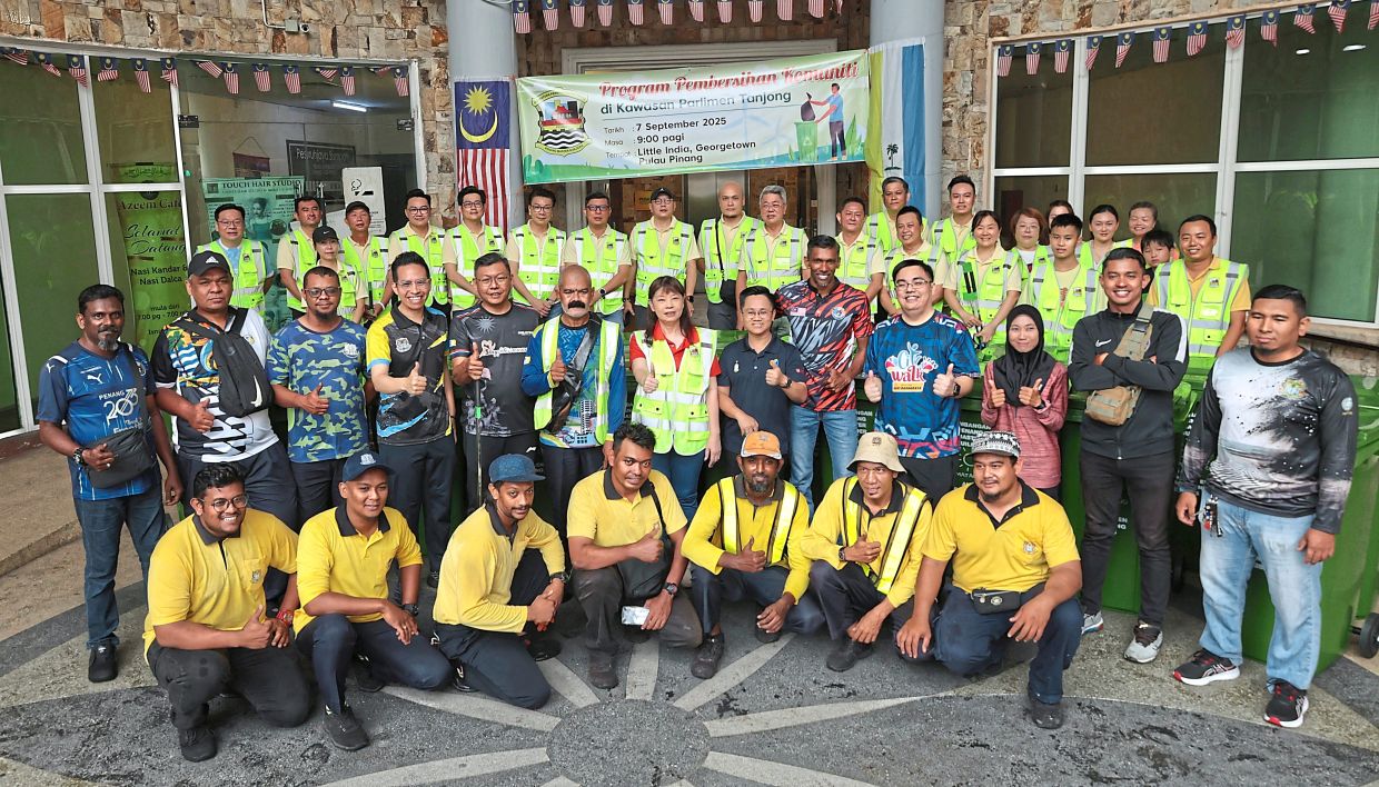 Lim (middle row, in red shirt and vest) with participants of the gotong-royong at Little India.