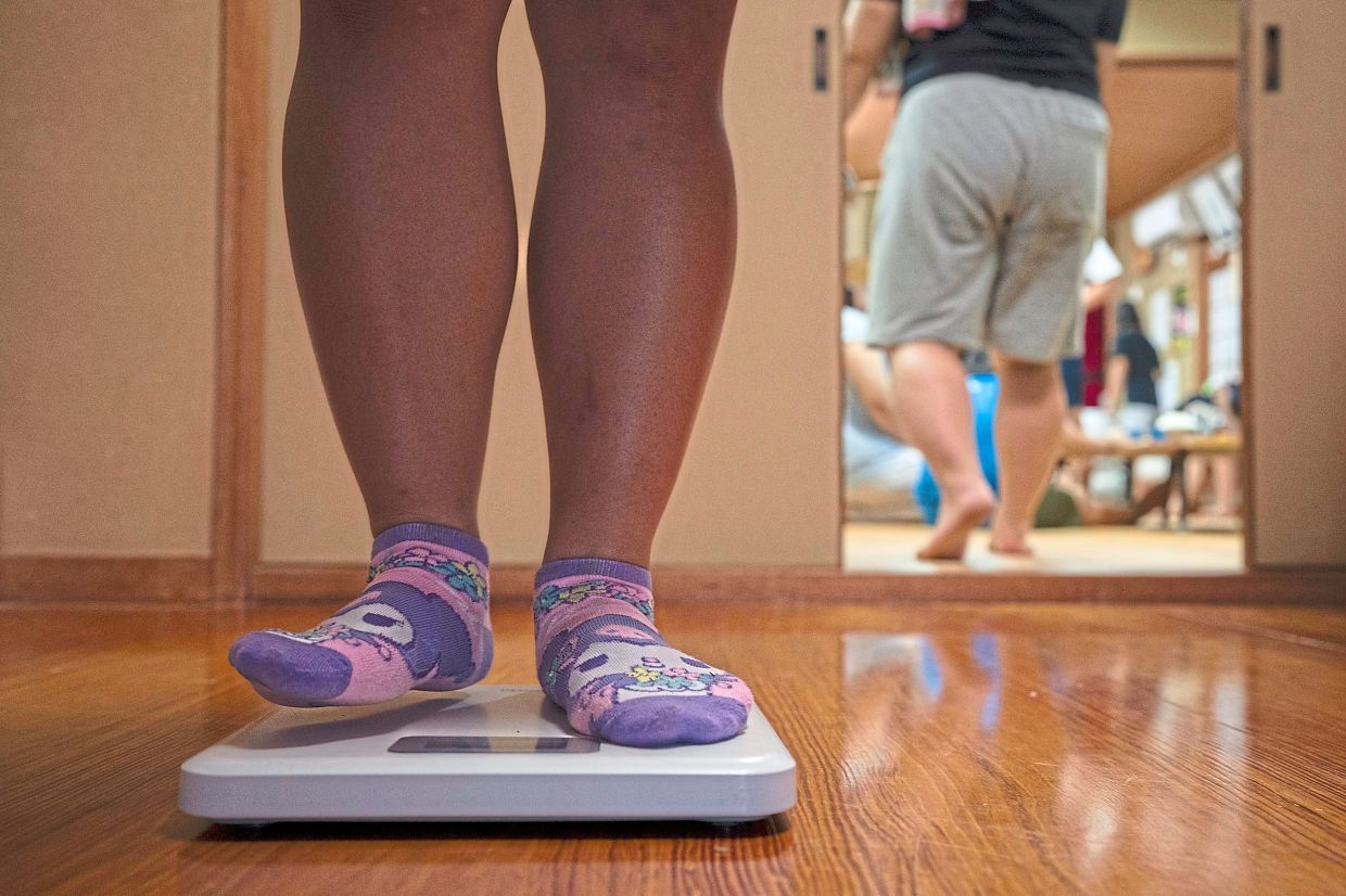A wrestler weighs herself on a scale. Photo: AP