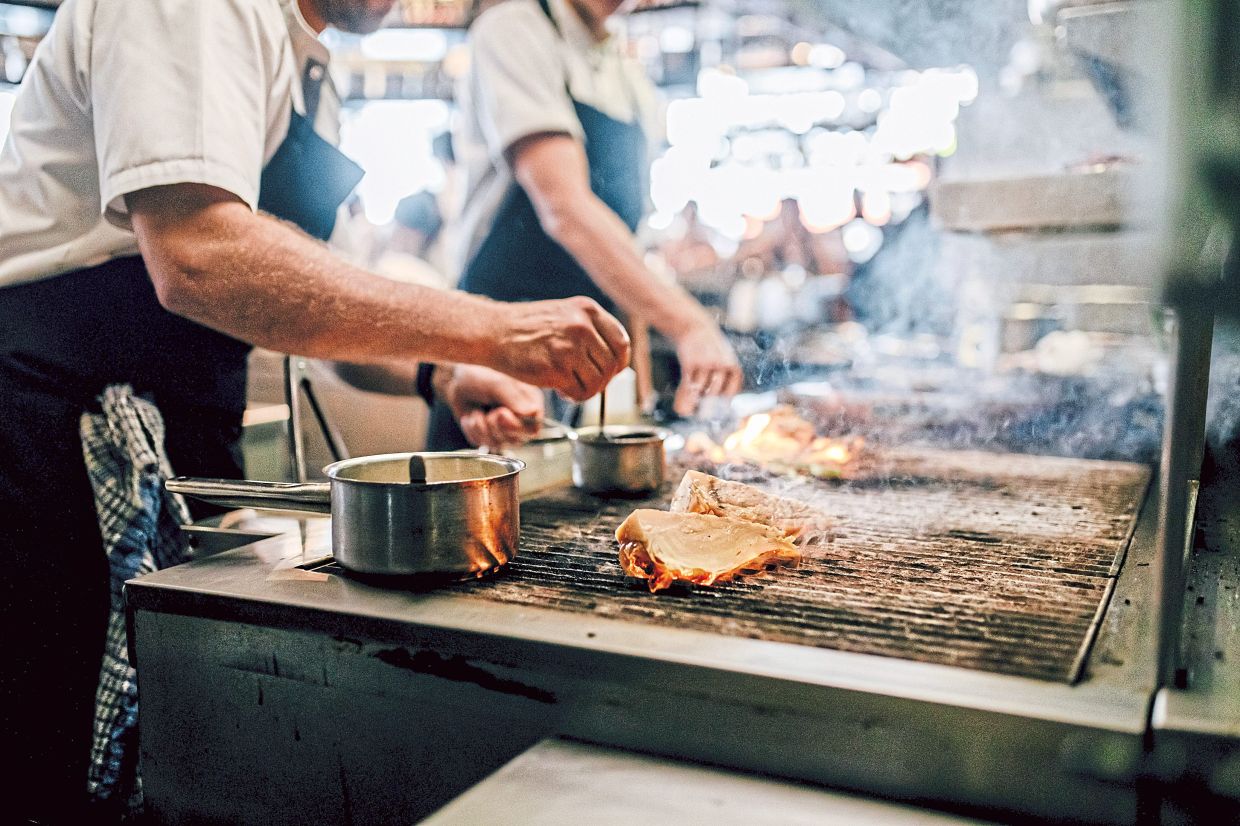 A chef at the London restaurant Fallow grills Hispi cabbage for a side dish with chorizo and sesame.
