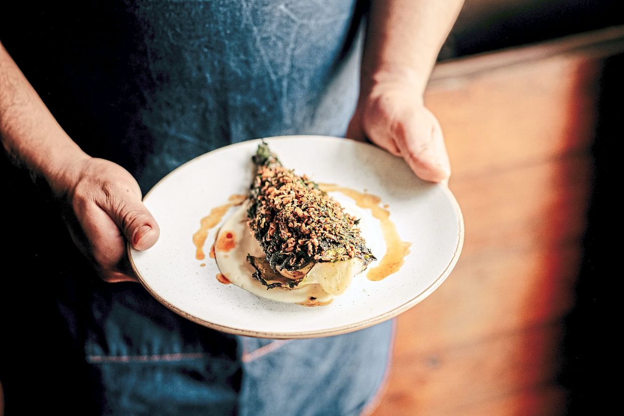 Grilled Hispi cabbage is served with mushroom XO sauce, celeriac puree and pumpkin seed furikake at Kudu Grill, a South African restaurant in London.