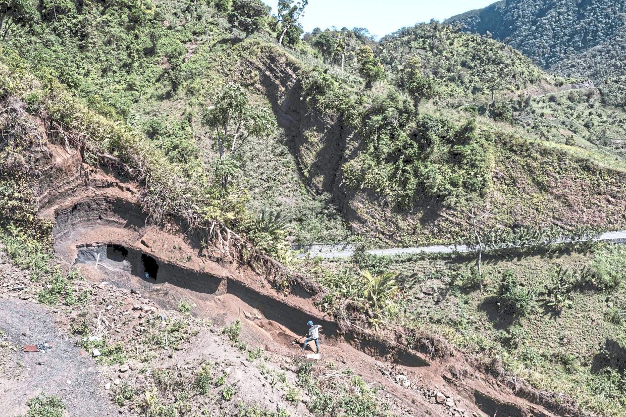 This aerial view shows a worker toiling on a deforested patch on a mountain side in Tsembehou.