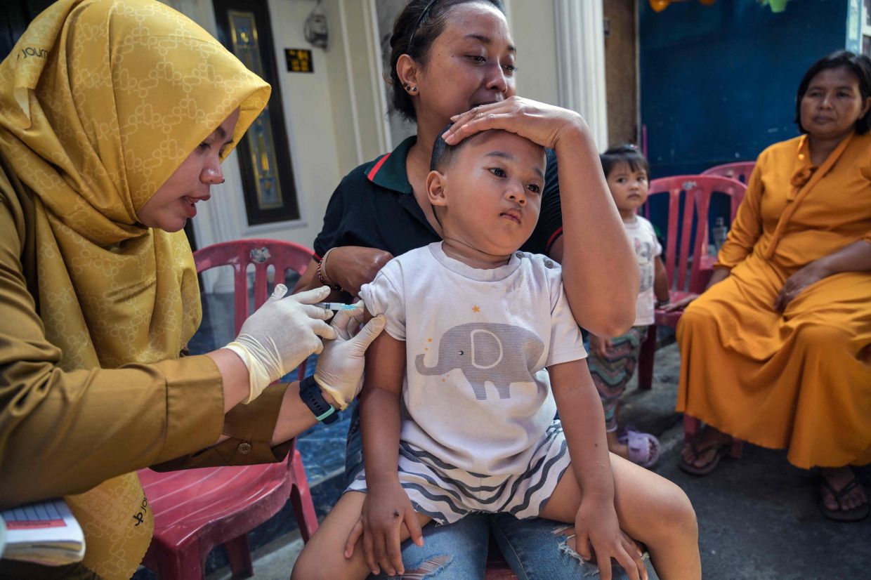 A health worker gives a measles vaccine to a child during a simultaneous immunisation in Surabaya on Friday, September 15, 2025. -- Photo by Juni KRISWANTO / AFP