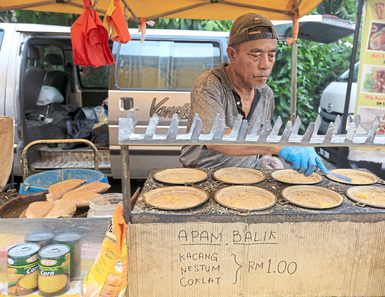 A trader preparing ‘apam balik’ filled with peanuts and corn.