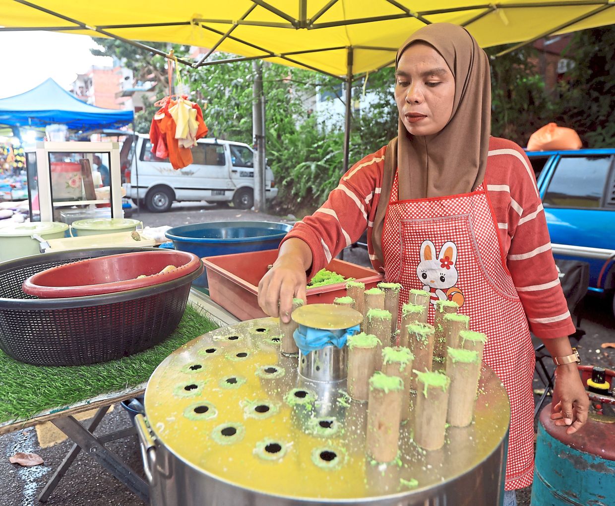 A trader preparing traditional steamed ‘putu bambu’ containing rice flour and palm sugar.