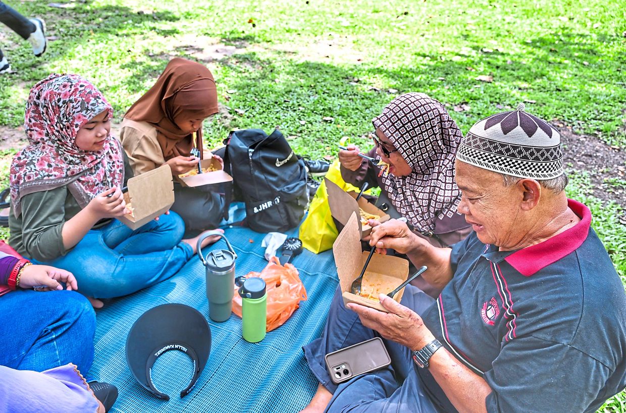 Good times: Families and friends enjoying the meals in a casual, picnic-style setting on the grass.