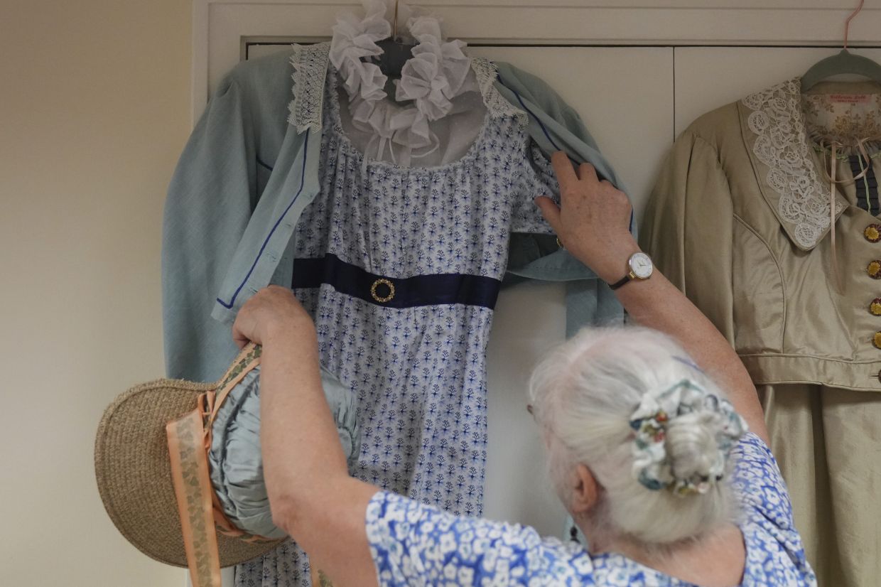 Kate Lobb, tailor and member of the Hampshire Regency Dancers, shows a Regency-era costume she made during a practice in Winchester, England. Photo: AP