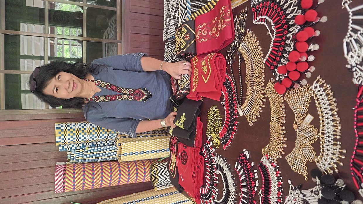 Catherline displaying some of the participants' crafts which they made during the training programme.