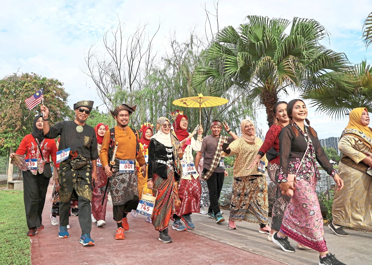 All smiles: Participants donned traditional costumes for the Cultural Colour Run in conjunction with the Malaysia Day celebration at Taman Tasik Titiwangsa. — AZMAN GHANI/The Star