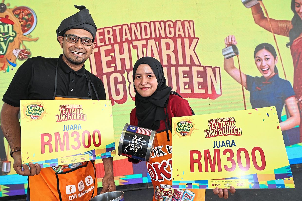 A brewing art: Teh Tarik King & Queen competition winners Syed Khaidir (left) with Nik Zakirah posing for a photo during FBM in Taman Tasik Titiwangsa. — AZMAN GHANI/ The Star