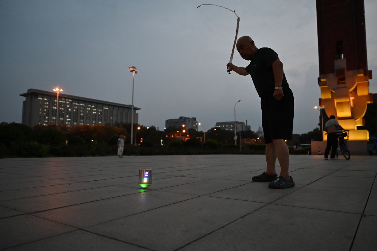 Wang swings a whip with steady, focused precision in a park near Beijing's Olympic Centre. For some Chinese retirees, these unconventional sports tools are part of their daily routine. Photo: Johannes Neudecker/dpa