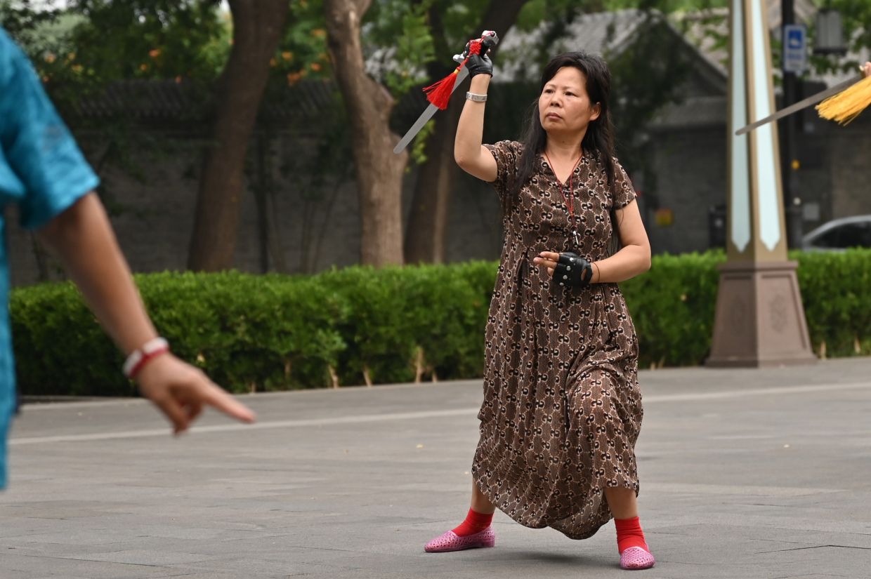Wei carries out a Tai Chi exercise using a sword. Photo: Johannes Neudecker/dpa