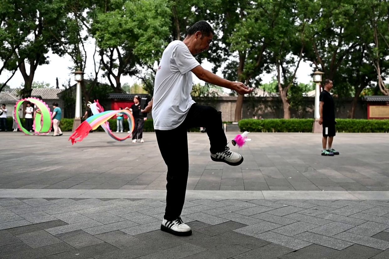 Lao Fan keeps a Jianzi in the air using his foot. Photo: Johannes Neudecker/dpa