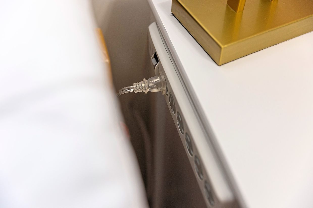 A multi-plug outlet attached to a desk in a model dorm room.