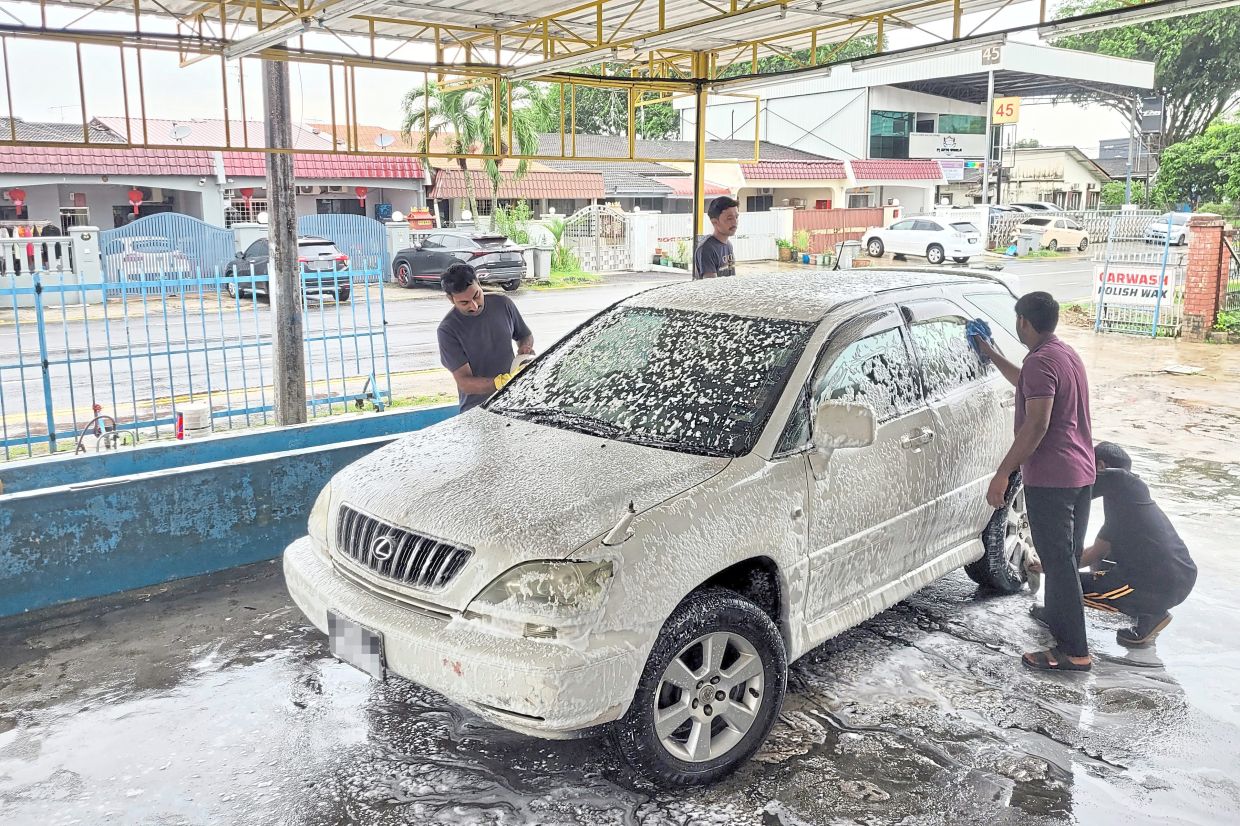 A neighbourhood carwash keeps its prices low despite proximity to Singapore.