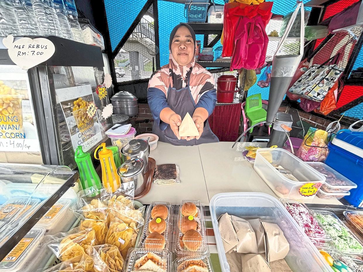 Riana sells nasi lemak telur for RM2 at Taman Tampoi Utama.