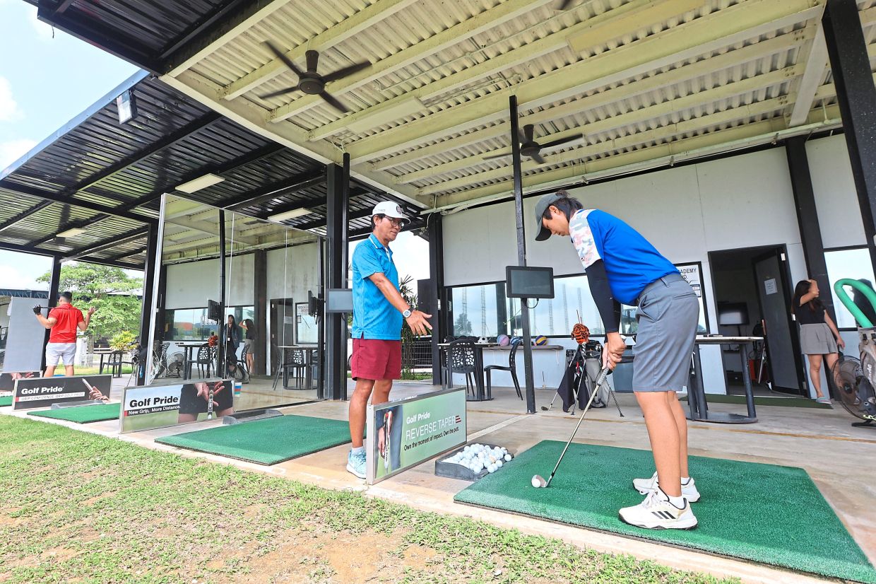 Hwang (left) conducting a lesson at a golf centre in Iskandar Puteri, where locals make up 70% of customers. — Photos: THOMAS YONG/The Star