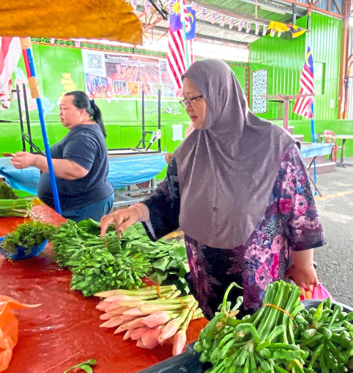 Hamidah choosing fresh vegetables at Pasar Borneo in Taman Megah Ria, Masai.