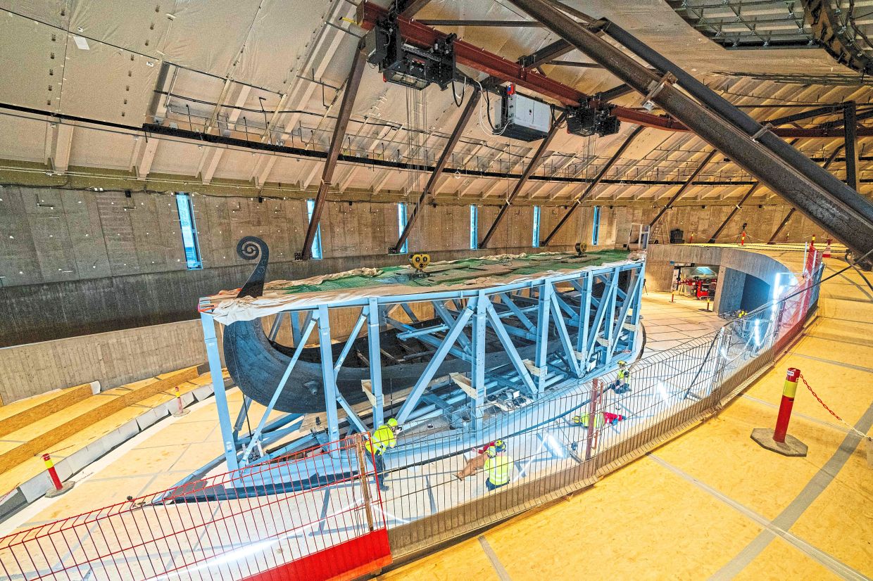 Workers lifting the Oseberg ship to move it to the new Viking Age Museum. — Reuters/AFP