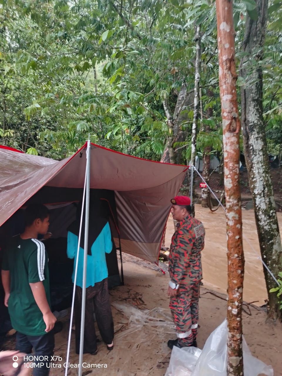 Firemen from the Kuala Kubu Baru fire and rescue station talking to campers along Sg Kerling to move to higher ground after a major kepala air (water surge) incident occurred in the area in the wee hours of Monday.