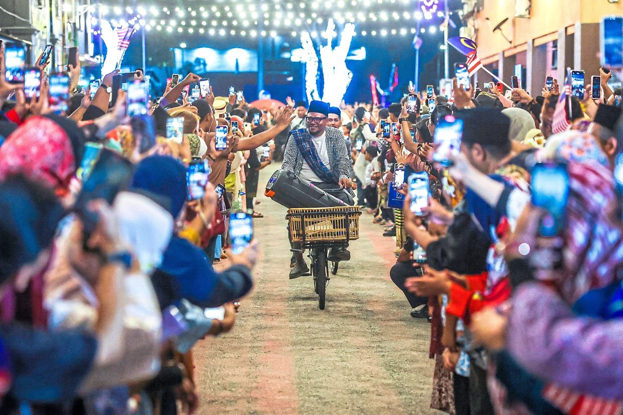 A group of cyclists on vintage bicycles receiving a warm welcome.