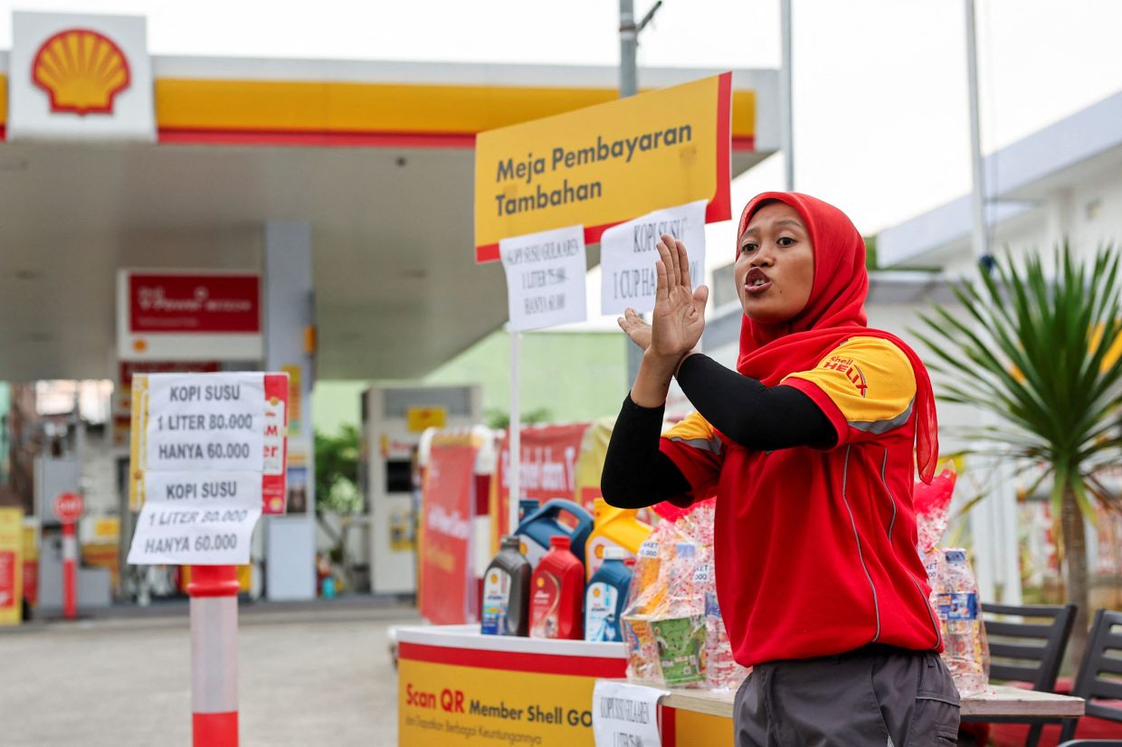 An employee gestures to customers about gasoline shortages at a Shell petrol station in Jakarta, Indonesia, on Friday, September 19, 2025.. -- Photo: REUTERS/Willy Kurniawan