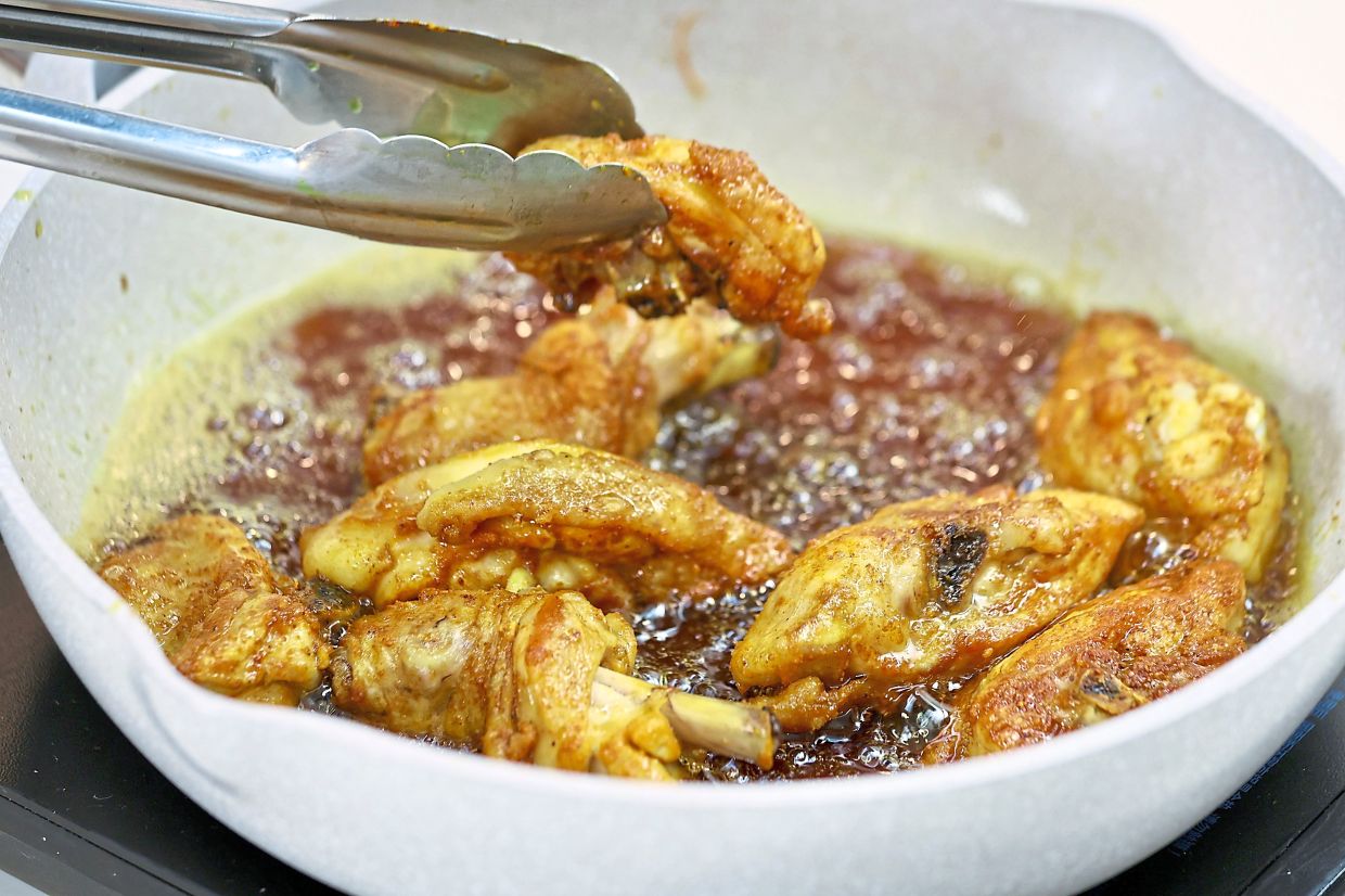 Fry batches of the marinated chicken in sesame oil until golden and crispy.