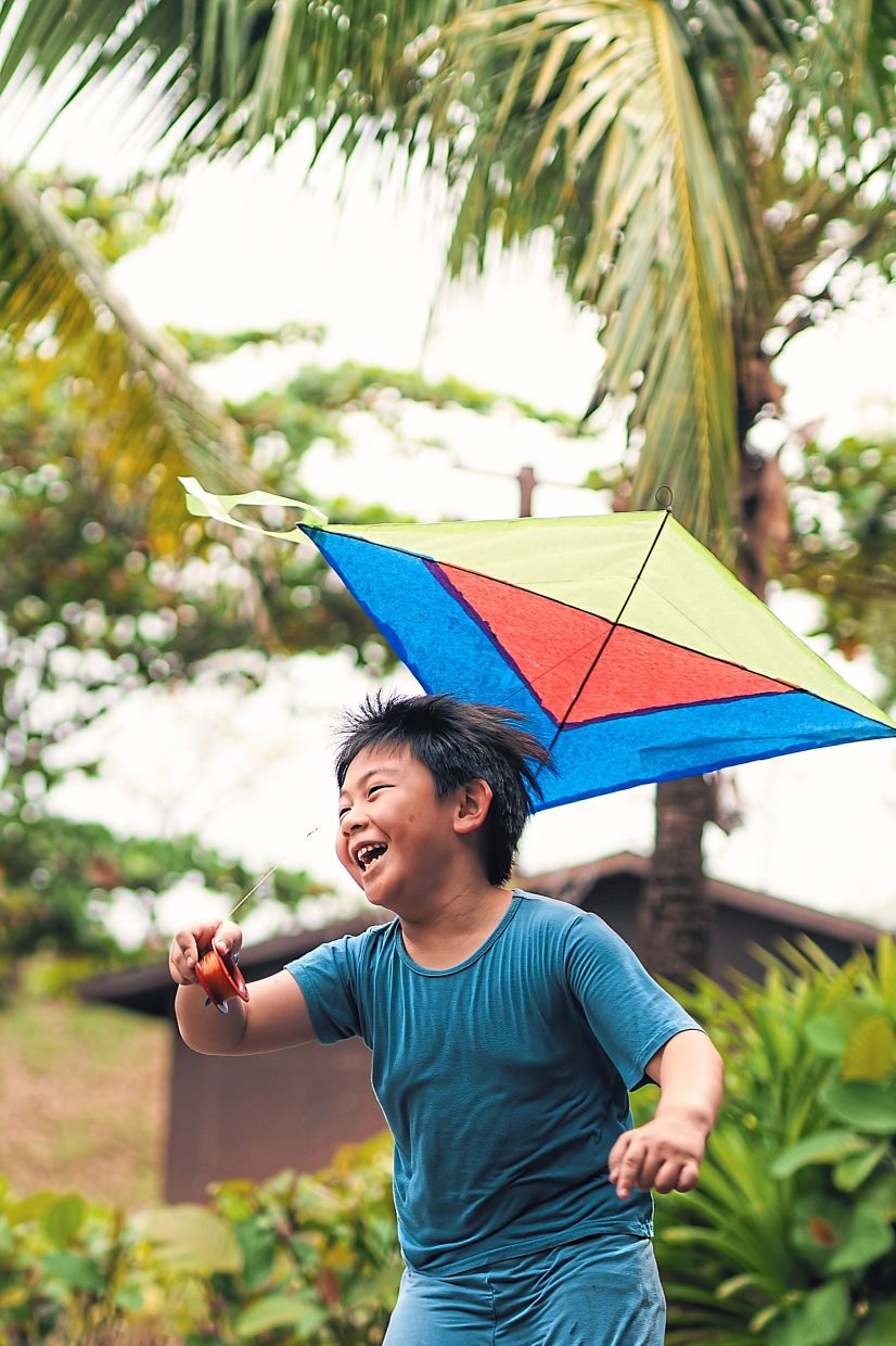 A young boy enjoying a kite he helped make at the kite-making workshop.