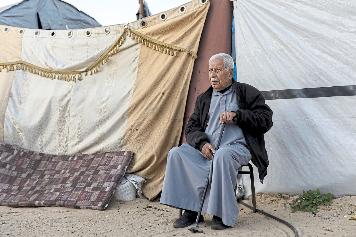Abdallah in front of the tent where he lives in Khan Yunis. Israel’s war in Gaza has displaced most of the 2.2 million Palestinian residents from their homes. Many of them fear it will be permanent, a reprise of the Nakba. — Saher Alghorra/The New York Times