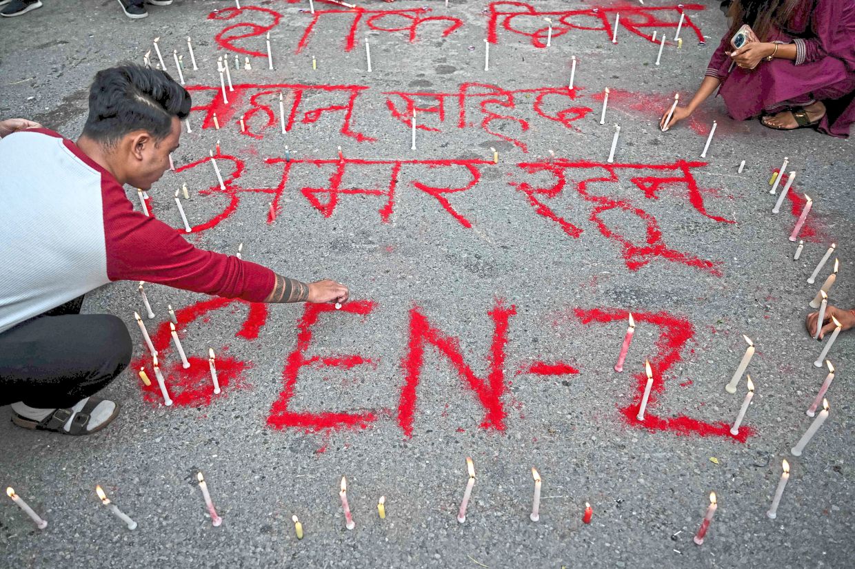 A man lighting candles beside the words ‘Long live martyrs’ during a silent tribute on the National Day of Mourning, held at Maitighar Mandala in Kathmandu to honour those killed in recent clashes.-AFP