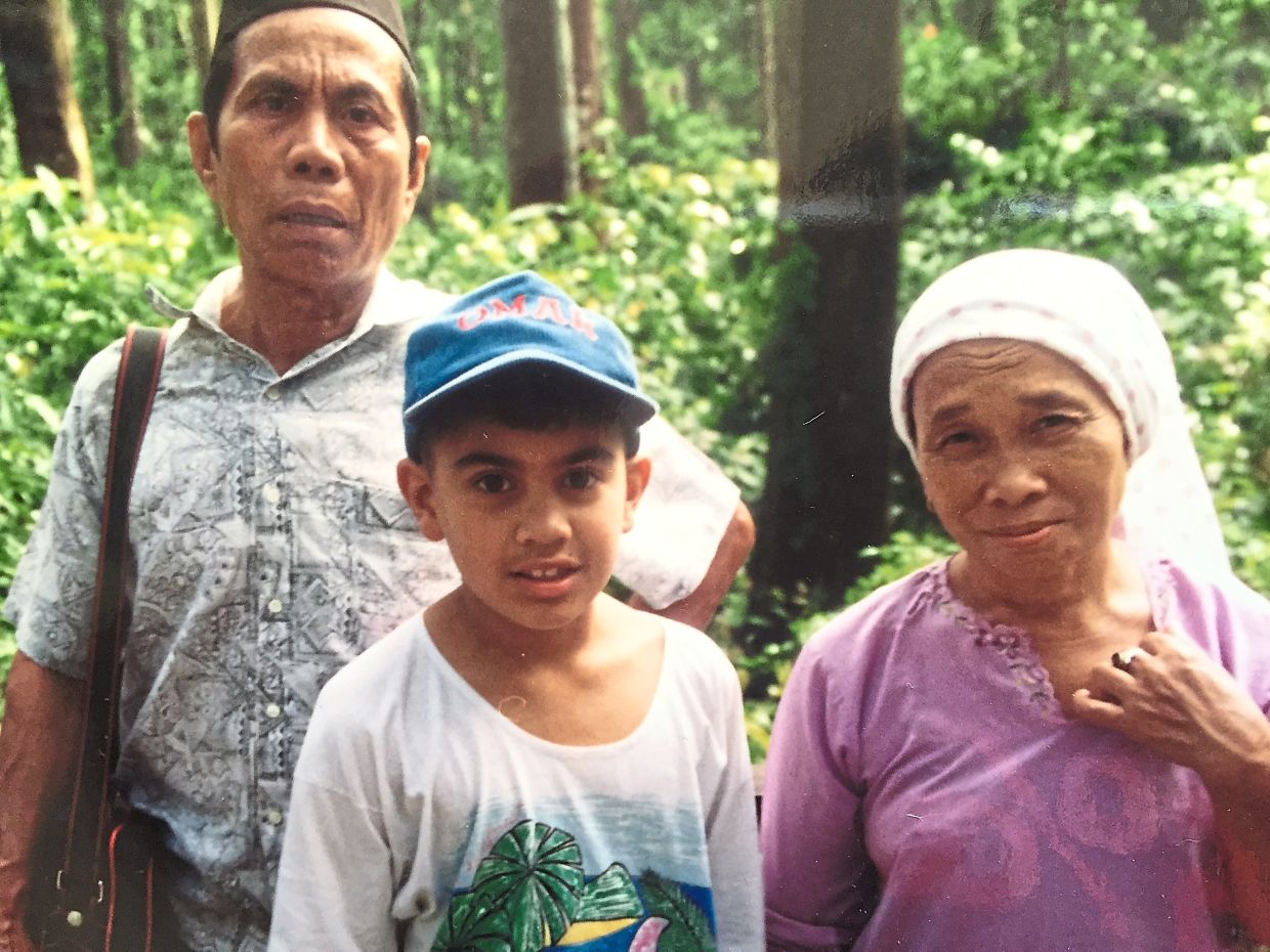 A young Omar with his grandparents, Lauya Garai (right) and Pidu Haji Taha, during a 1993 visit to Sandakan, a place that would later inspire his stories. Photo: Omar Musa