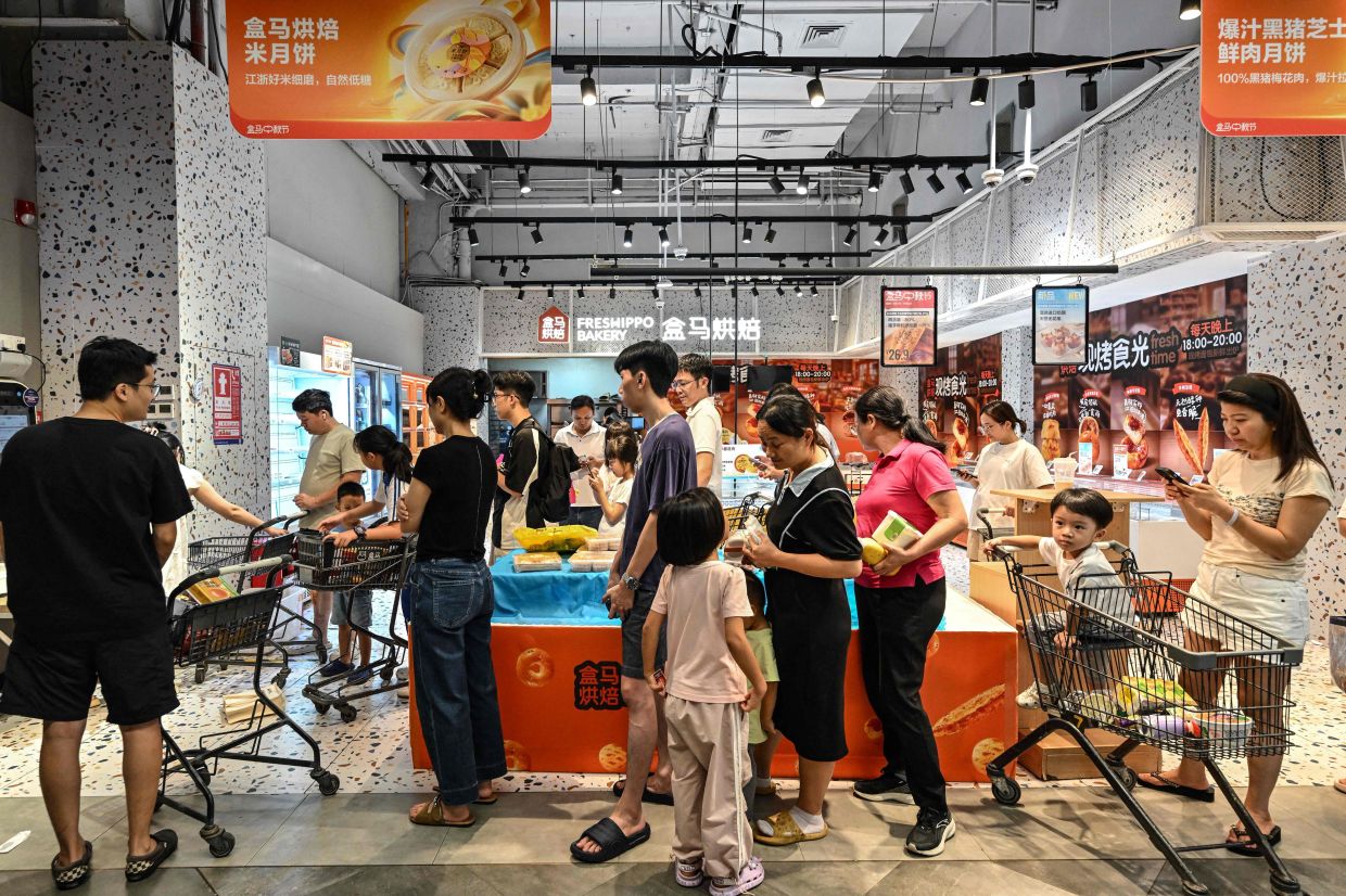 People rush to buy groceries at a supermarket as the Super Typhoon Ragasa approaches in Shenzhen, in southern China's Guangdong province, on Monday, September 22, 2025. The Chinese city of Shenzhen began preparing to evacuate 400,000 people while residents of the northern Philippines sought shelter from gale-force winds on Monday as Super Typhoon Ragasa continued on a collision course with southern China. -- Photo by Adek BERRY / AFP