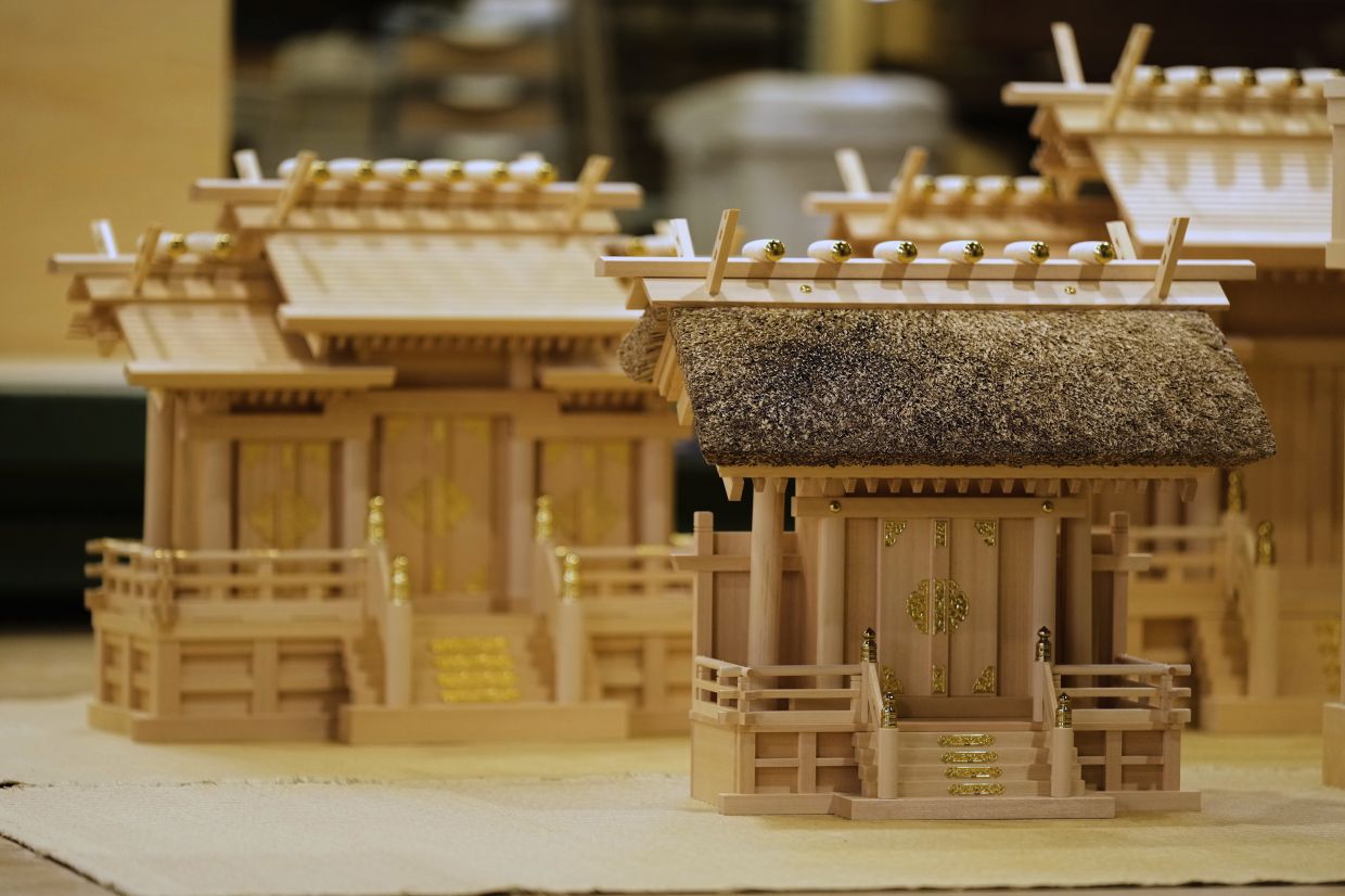 Handmade Shinto shrine altars are seen at Miyachu factory, which crafts miniature replicas of the Ise Jingu shrine, in Tamaki, central Japan. - AP
