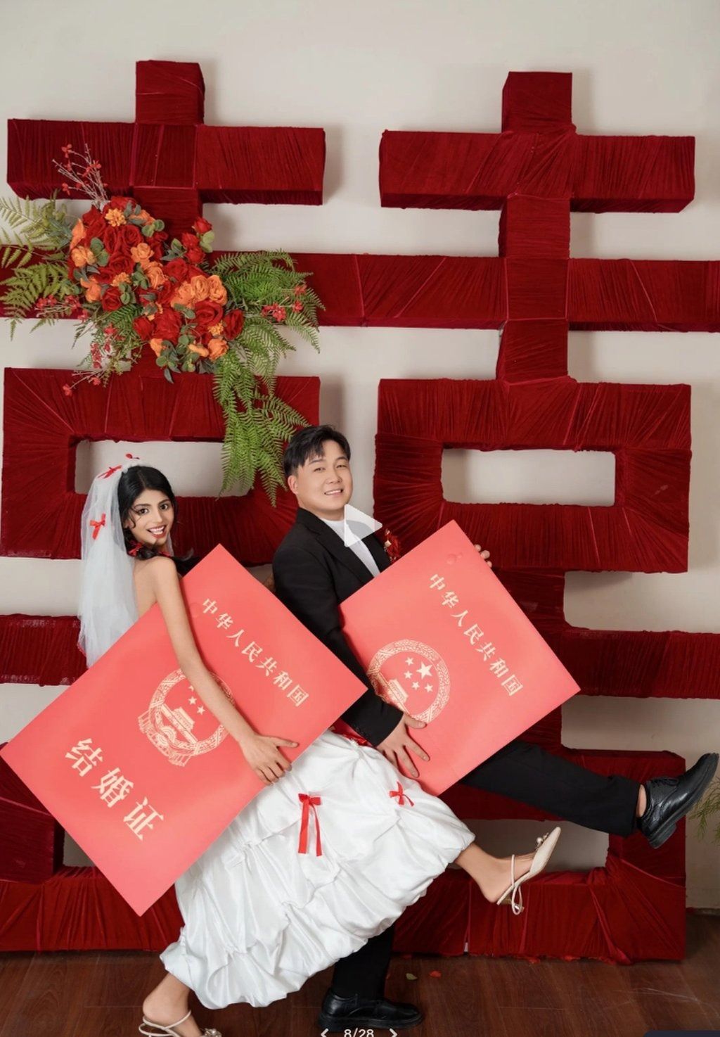 The couple carry oversized lai see packets. The wedding will follow local traditions, but there will be no bride price. -- Photo: Douyin
