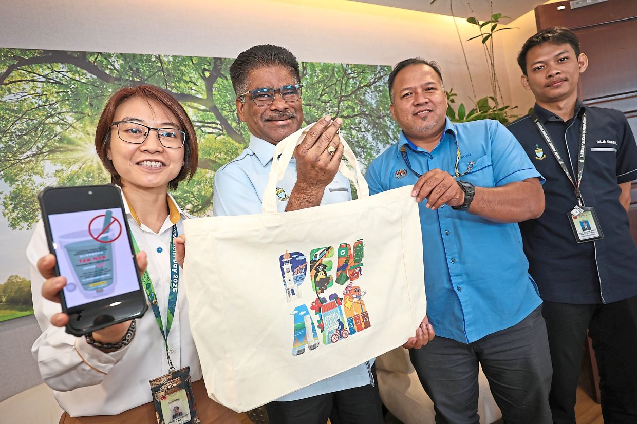 (From left) Tan, Sundarajoo and Penang Island City Council officers with a reusable bag and a snapshot of the no plastic straw campaign poster at Komtar.