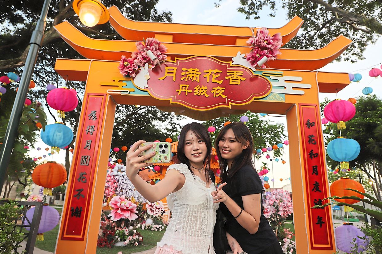 (Inset) Visitors Wen Lee, 19, (left) and Suzy Tan, 22, taking photos under the grand arch at the Mid-Autumn Festival scene. — LIM BENG TATT/The Star
