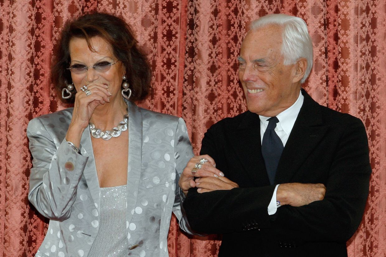 Italian actress Claudia Cardinale and fashion designer Giorgio Armani smile as they attend a ceremony at the Elysee presidential palace in Paris, where they received the French Legion d'Honneur medal, on July 3, 2008. Photo: AFP