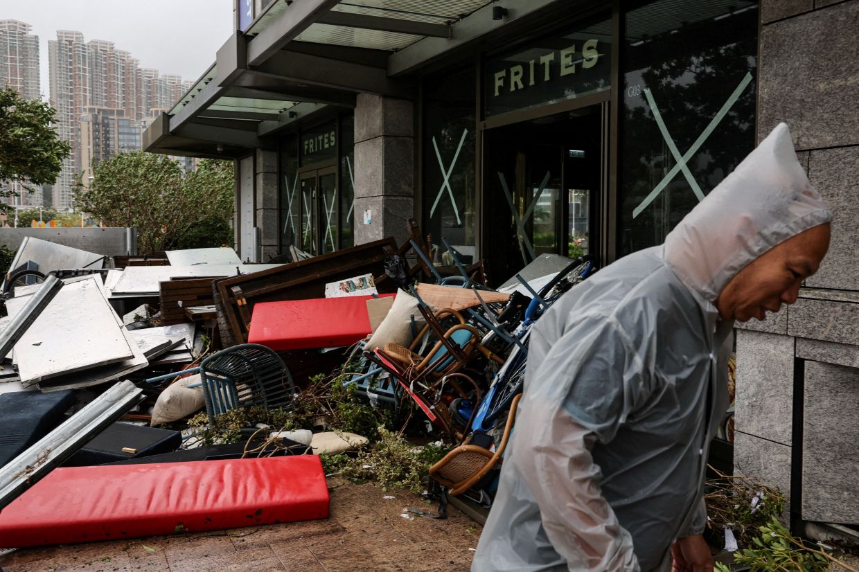 A man walking next to a damaged restaurant, in the aftermath of Super Typhoon Ragasa in Hong Kong on Sept 24. - Reuters