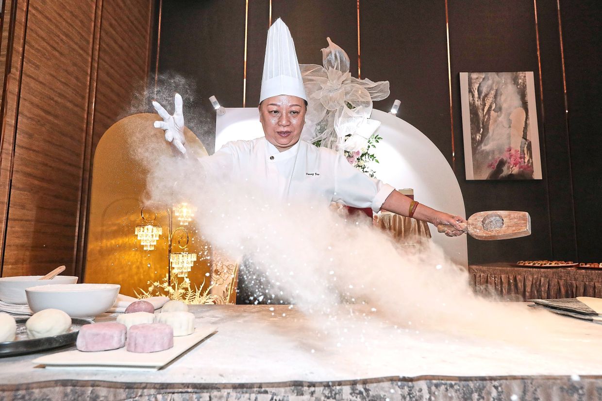 Foo demonstrating how snow-skin mooncakes are made.