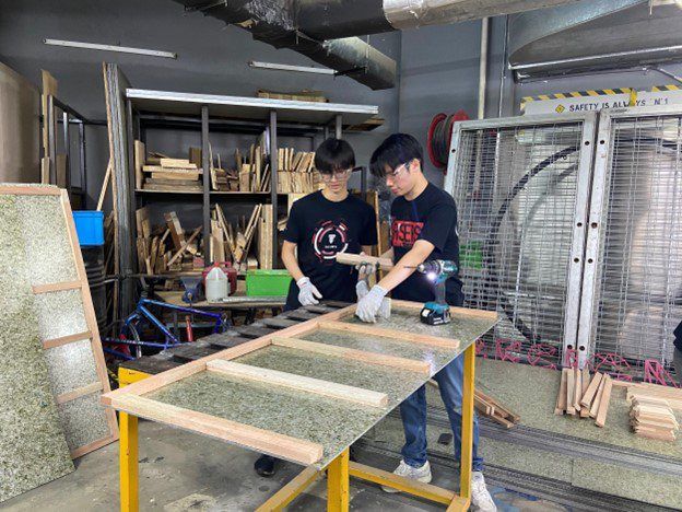 Edwin (left) building a CAREbinet made from sustainable materials for underserved communities.