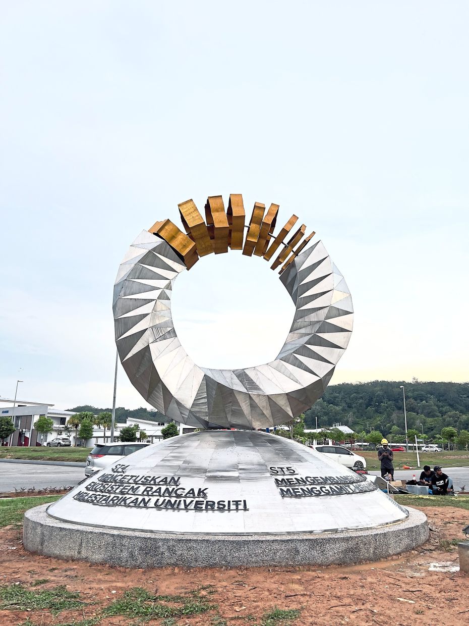 Ramlan created Kesidang Mas at Universiti Teknikal Malaysia Melaka. using his preferred materials: Stainless steel, brass, and stone.
