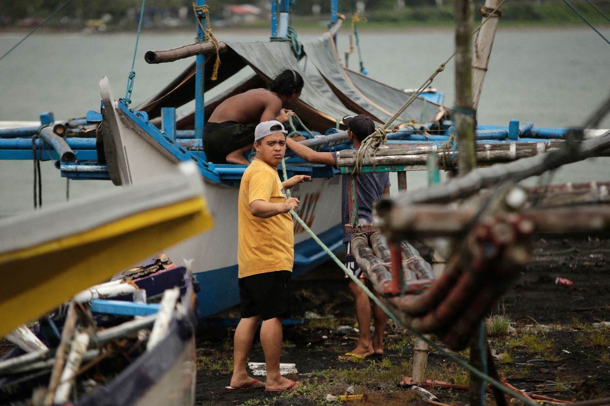 Residents secure their fishing boats at a village in Legaspi City, Albay province, south of Manila, on Thursday, September 25, 2025, ahead of Tropical Storm Bualoi's landfall in the Bicol region. The Philippines shut schools and scrapped flights on September 25 as a fresh storm threatened to hit just days after a super typhoon killed nine people in the archipelago. -- Photo by CHARISM SAYAT / AFP