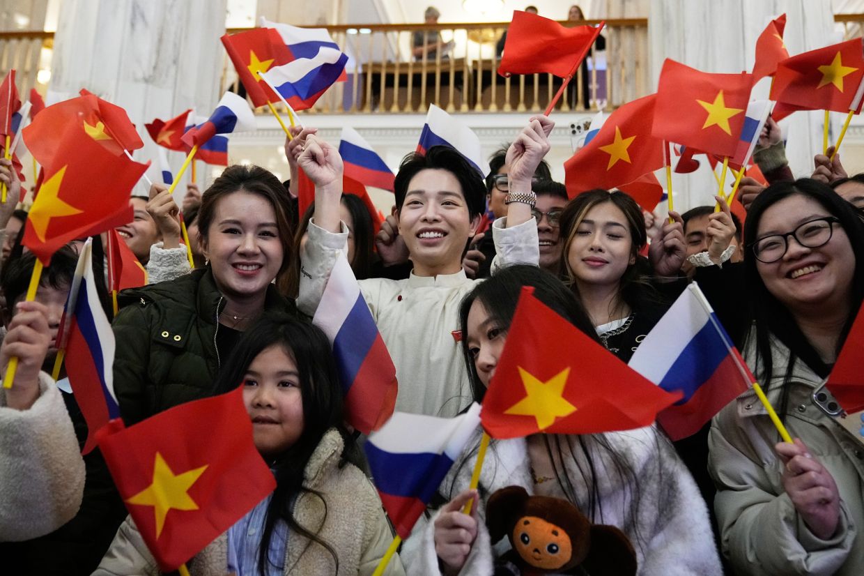 Vietnam's Duc Phuc, center, winner of the International Music Competition - Intervision, poses for a photo with fans as he leaves a hotel in Moscow, Russia. -- AP Photo/Pavel Bednyakov
