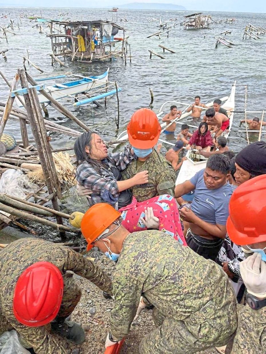 Troopers from the 63rd Infantry ‘Innovator’ Battalion of the Philippine Army carrying residents to land after search andrescue operations in Guiuan, Eastern Samar. — AFP/AP