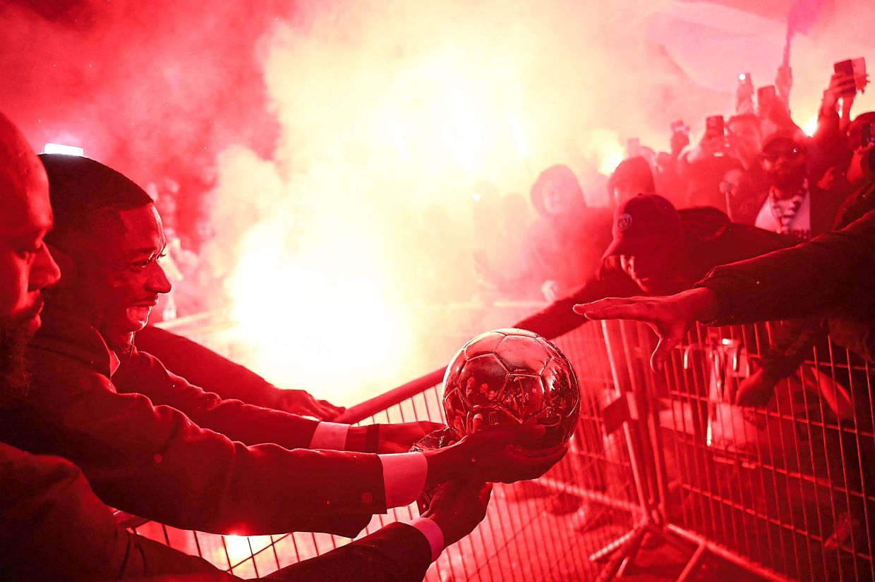Dembele celebrates with supporters after receiving the Ballon d’Or award outside the Theatre du Chatelet in Paris on Sept 22. — AFP