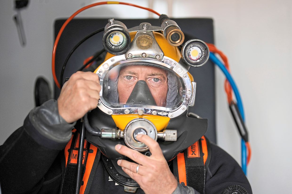 A diver checking his equipment before getting into the water during a recovery session.