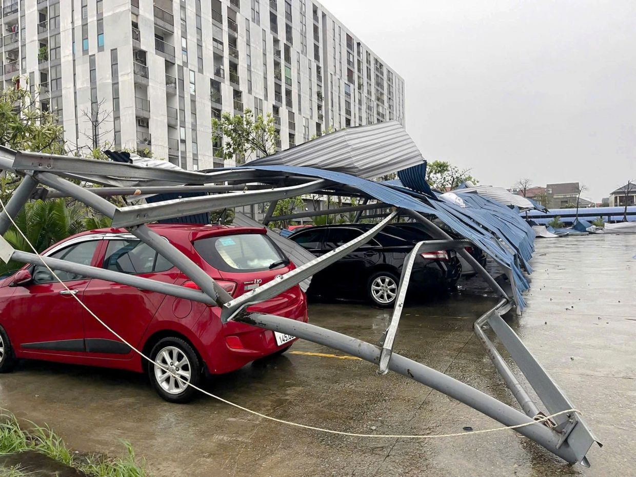 Roof of a parking shed is seen collapsed on cars in the aftermath of Typhoon Bualoi in Thanh Hoa on Sept 29, 2025. - AP