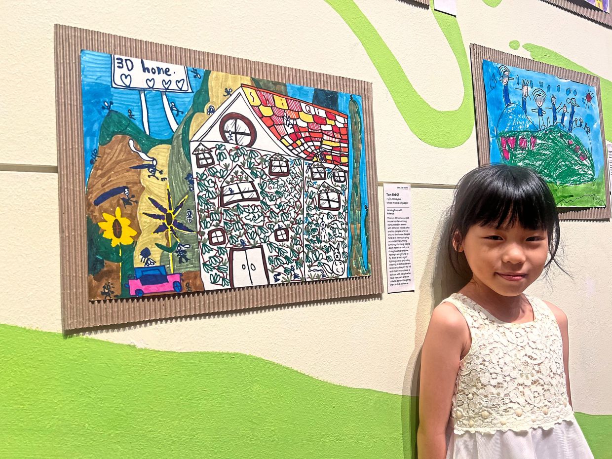 Shi Qi beside her artwork, which depicts peace as a place of friendship and happiness.
